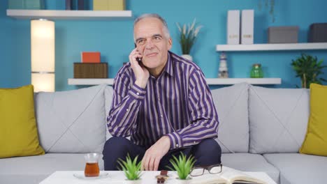 Happy-and-cheerful-old-man-talking-on-phone-call-at-home.