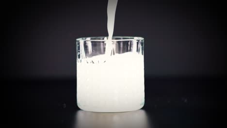 milk being poured into a clear glass