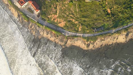 aerial view of drone flying above beautiful coast with views of ocean waves and water crashing on to sandy coast