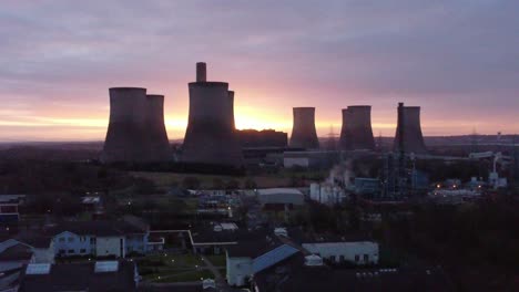 fiddlers ferry disused coal fired power station with sunrise horizon behind landmark, aerial view orbit right