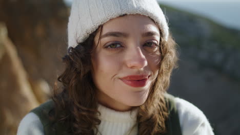 portrait girl blowing hair at rocky mountain. beautiful tourist looking camera