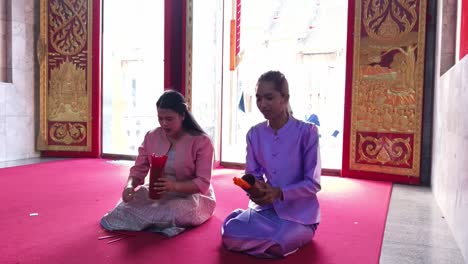 women praying at a thai temple