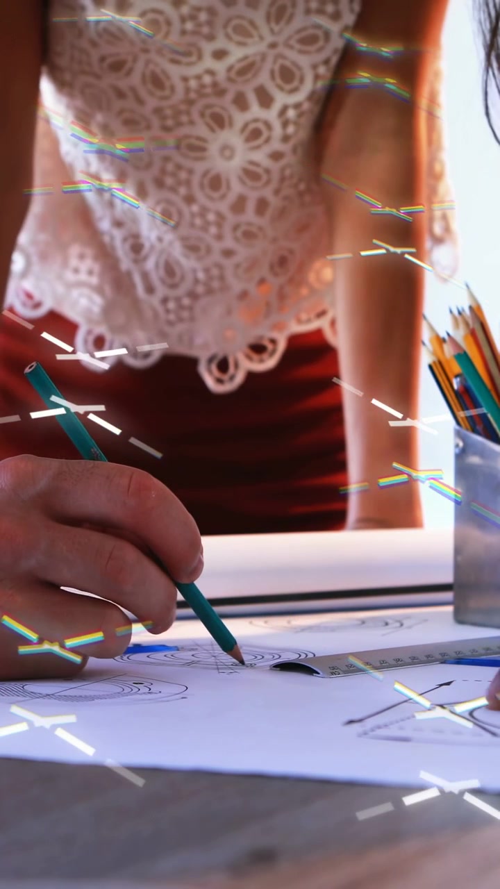 Vertical video: Woman at desk, green pencil starting rings, peer pointing, overlay aiding design