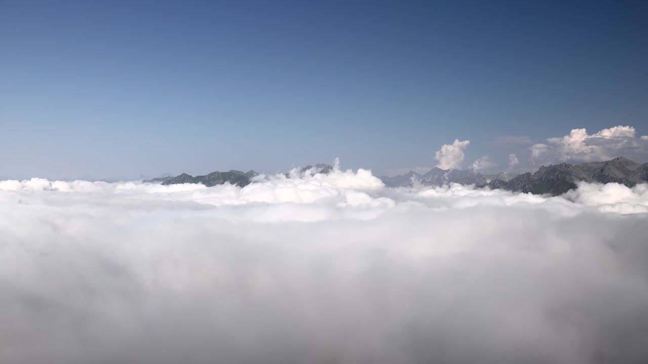 Aerial View of Mountain Peaks Rising Above a Sea of Clouds