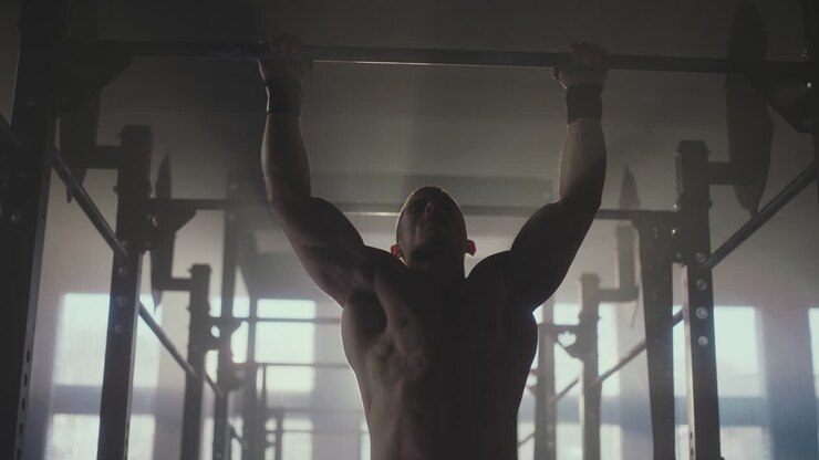 Man Performing Pull-Ups in Gym