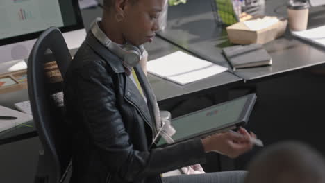 young-business-people-meeting-beautiful-redhead-team-leader-woman-using-tablet-computer-showing-creative-project-ideas-on-screen-sharing-strategy-colleagues-collaborating-in-office-briefing