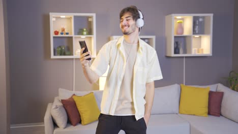 Happy-young-man-listening-to-music-with-headphones-at-home.