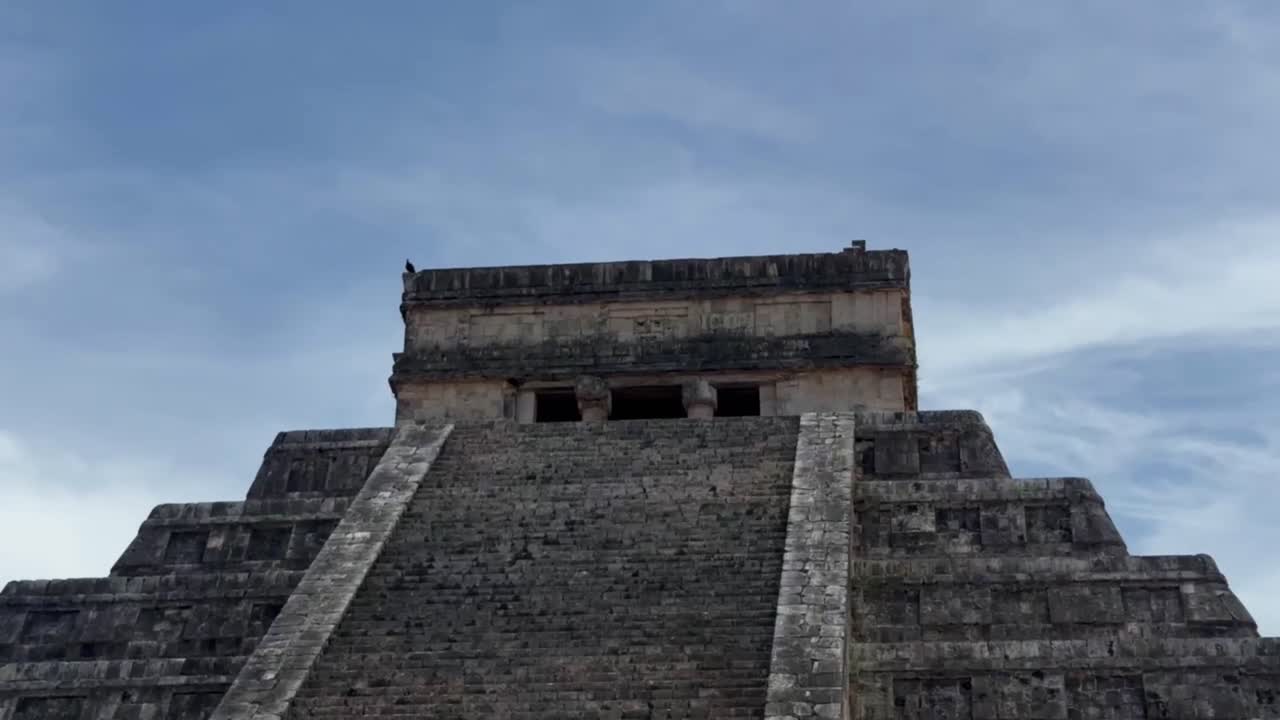 Handheld close-up booming down shot of the steep steps at El Castillo ancient pyramid in Chichen Itza, Mexico. 4K