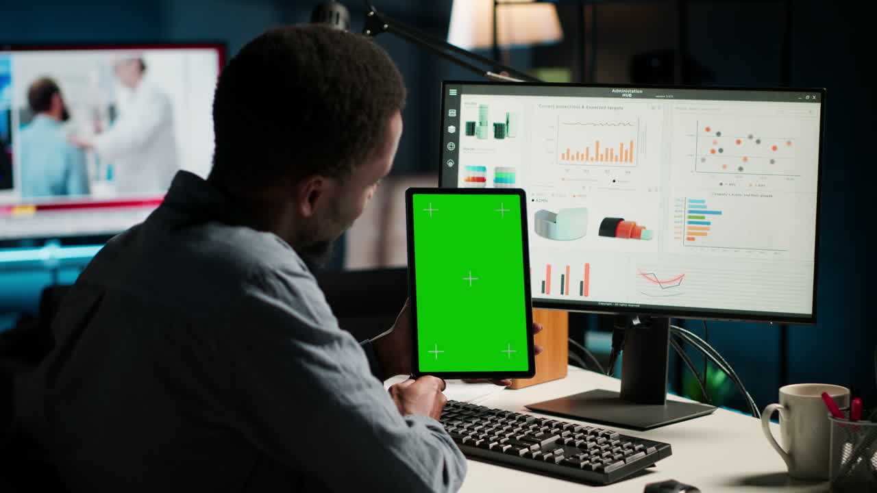 joven examinando fondos para un programa y sosteniendo una tableta con una maqueta