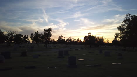 Low-aerial-dolly-through-a-graveyard-during-dusk