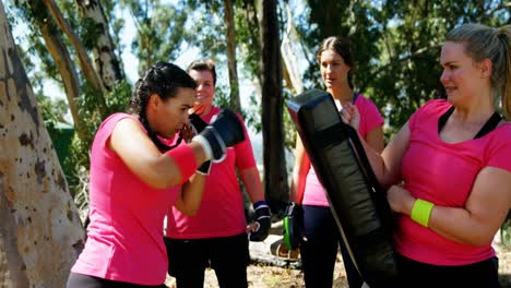 mujer practicando boxeo en el campamento de entrenamiento