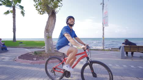 man riding a bike by the sea.