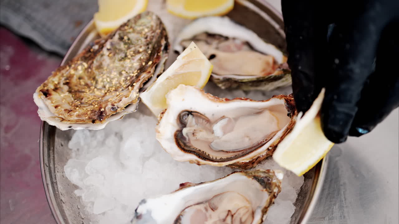 Close up of a bucket with raw oyster with lemons on ice at a restaurant