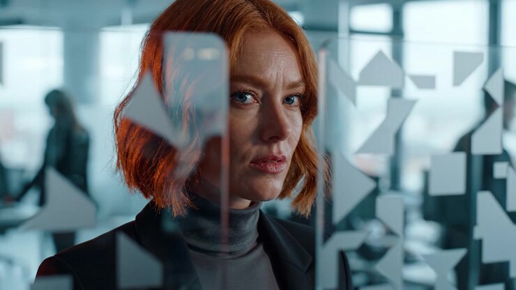 A Focused Professional Woman in a Modern Office Environment, Captured Through Glass Panels with Abstract Shapes Reflecting Concentration and Determination