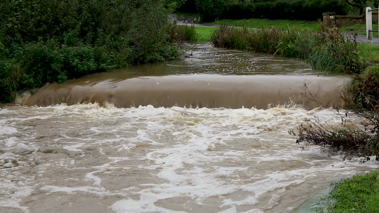 The river Gwash flowing through the village of Braunston in Rutland heavily swollen after heavy rains