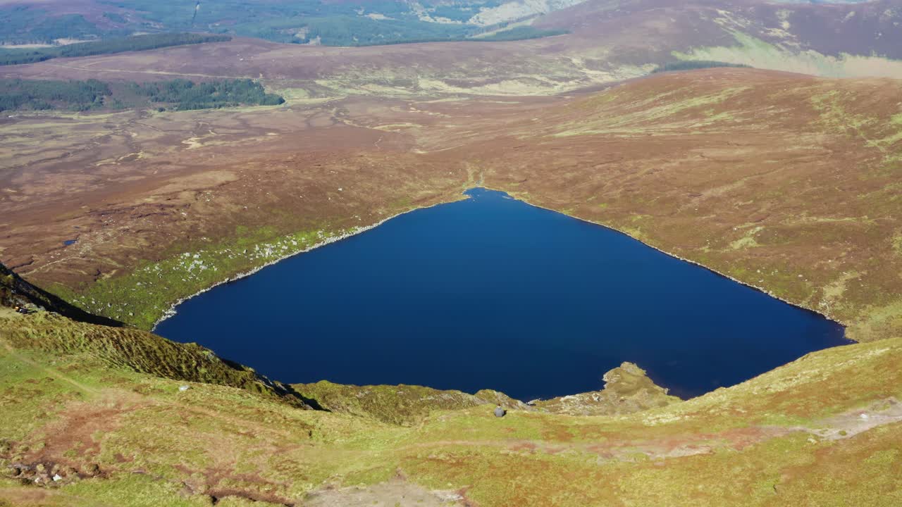 Aerial View of Hiker Sitting on Mountain Top Facing Lough Ouler in Wicklow