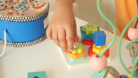 child playing with colorful wooden toys