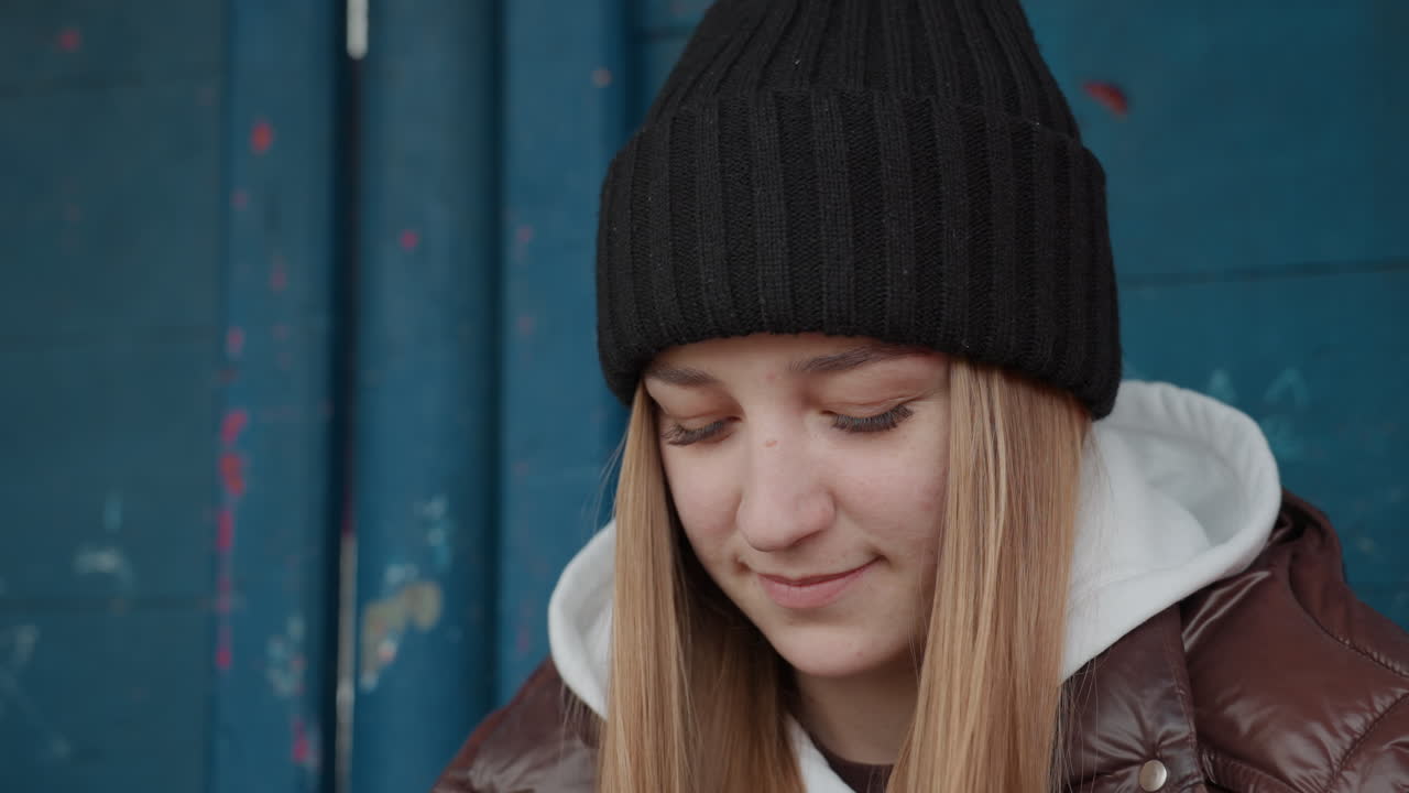 Отдыхающая молодая девушка, женщина в прохладной одежде с поддержкой опирается на цветную стену, юная девушка смотрит вниз, а женщина в холодной одежде уверенно опирается на ярко-синюю поверхность