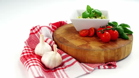 cherry tomatoes and garlic with bowl of pasta