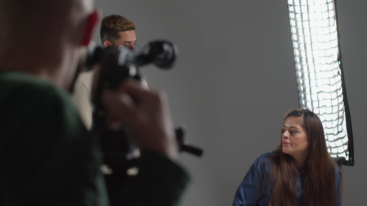 актеры снимают фильм или видео в студии с кинокамерой и звукозаписывающей командой