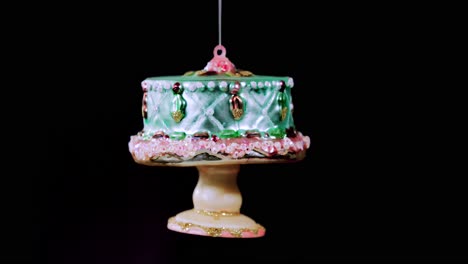 single-birthday-cake-Christmas-ornament-with-black-background,-close-up