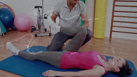 trainer assisting client leg stretch on blue mat in fitness studio, with animated motion guide
