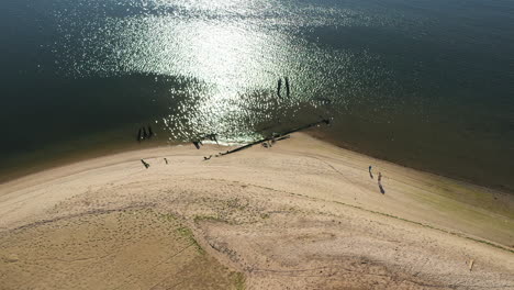 aerial-drone-camera-orbit-right-over-Shell-Bank-Creek-in-Brooklyn,-with-the-creek-shore---water-in-view-with-fisherman---his-kid-part-1