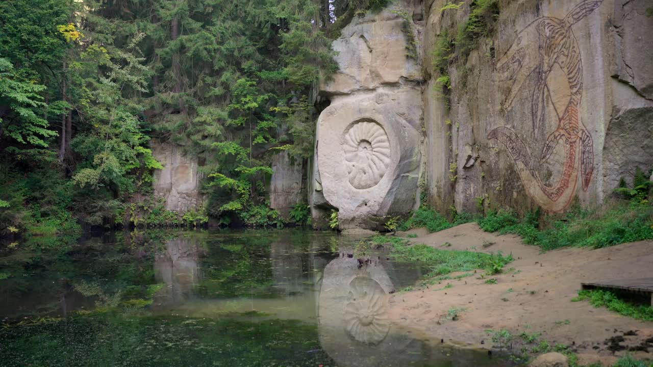 Statues carved into rocks depicting prehistoric animals and plants in the Kubíček sandstone quarry, Czech Republic