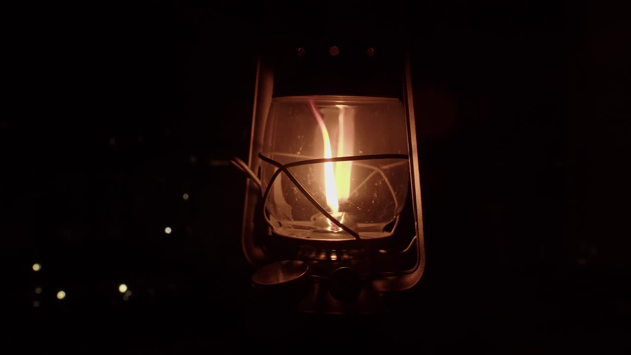 검은색 바탕에 손잡이에 오렌지색 불꽃 스을 가진 기름 랜턴