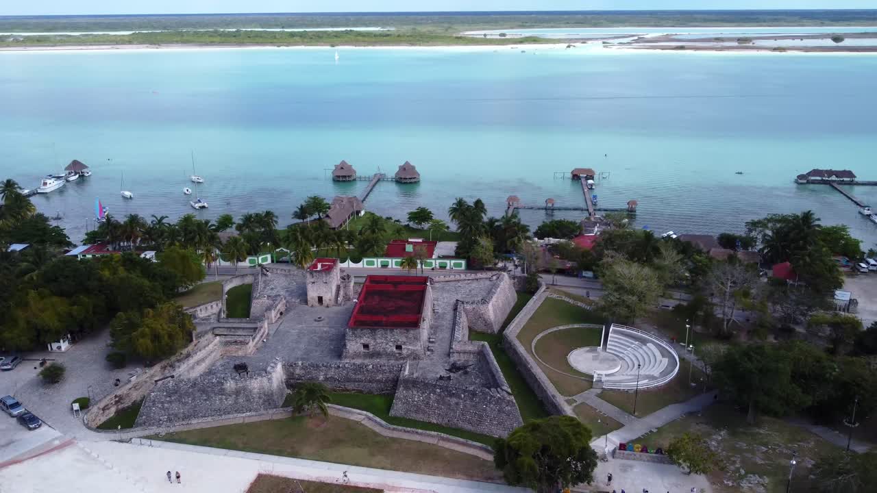 drone rotate around fuerte de san Felipe in Bacalar mexico travel destination with blue lagoon lake and tropical beaches