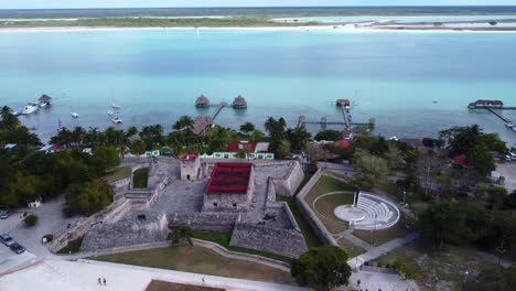 drone-rotate-around-fuerte-de-san-Felipe-in-Bacalar-mexico-travel-destination-with-blue-lagoon-lake-and-tropical-beaches