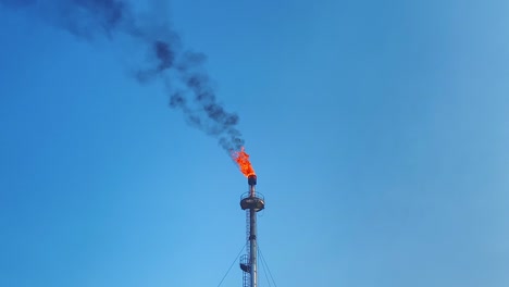 clip de dron de la enorme llama que sale de la chimenea de una fábrica de gas natural