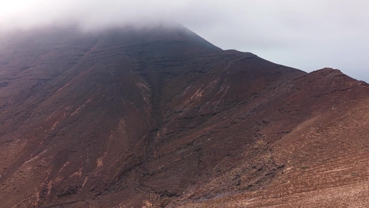 Vista aerea di una cima montuosa vulcanica con nuvole basse