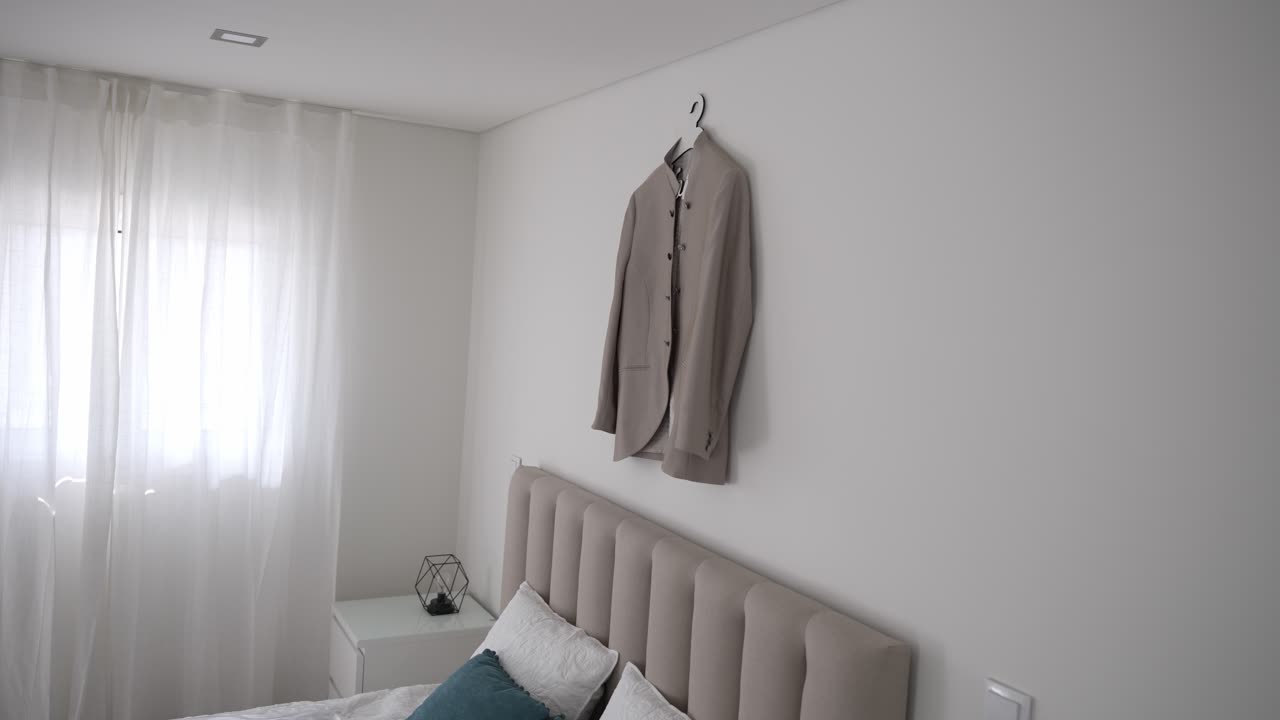 색 침실 벽에 매달린 베이지 웨딩 슈트, 창문에서 온화한 빛, 현대적인 미니멀리즘 장식