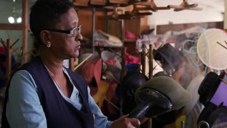 mujer de raza mixta trabajando en una fábrica de sombreros