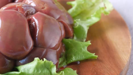 raw fresh lamb kidneys on a chopping board ,