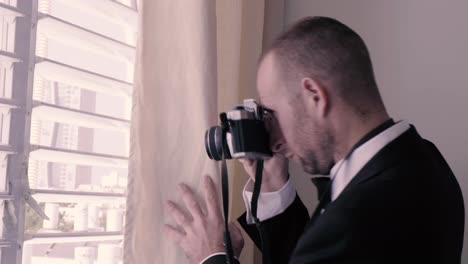 man spying from a window and taking pictures