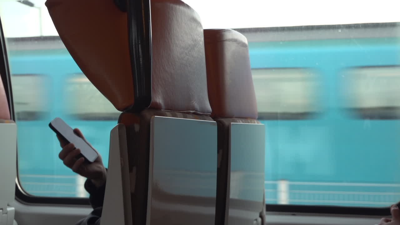 Villefranche sur Mer, France - March 24, 2025: View of the back of the window seats on a train passing by a station