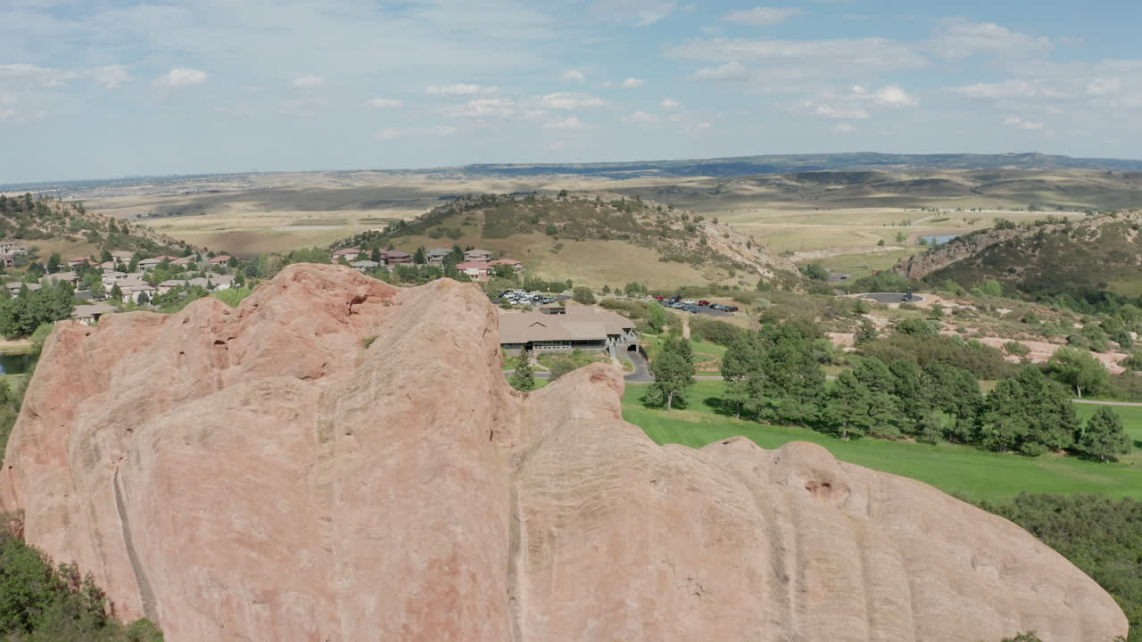 campo de golf de punta de flecha en littleton colorado con césped verde, rocas rojas y cielos azules