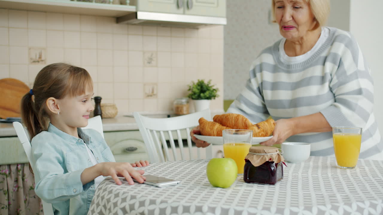 abuela y nieta desayunando