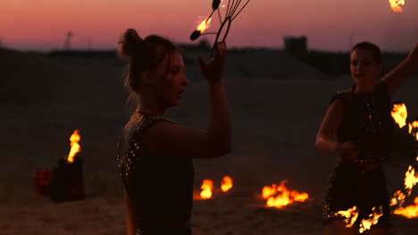 professional dancers women make a fire show and pyrotechnic performance at the festival with burning sparkling torches