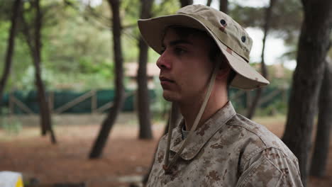 soldier stands at attention saluting the general in the woods with trees