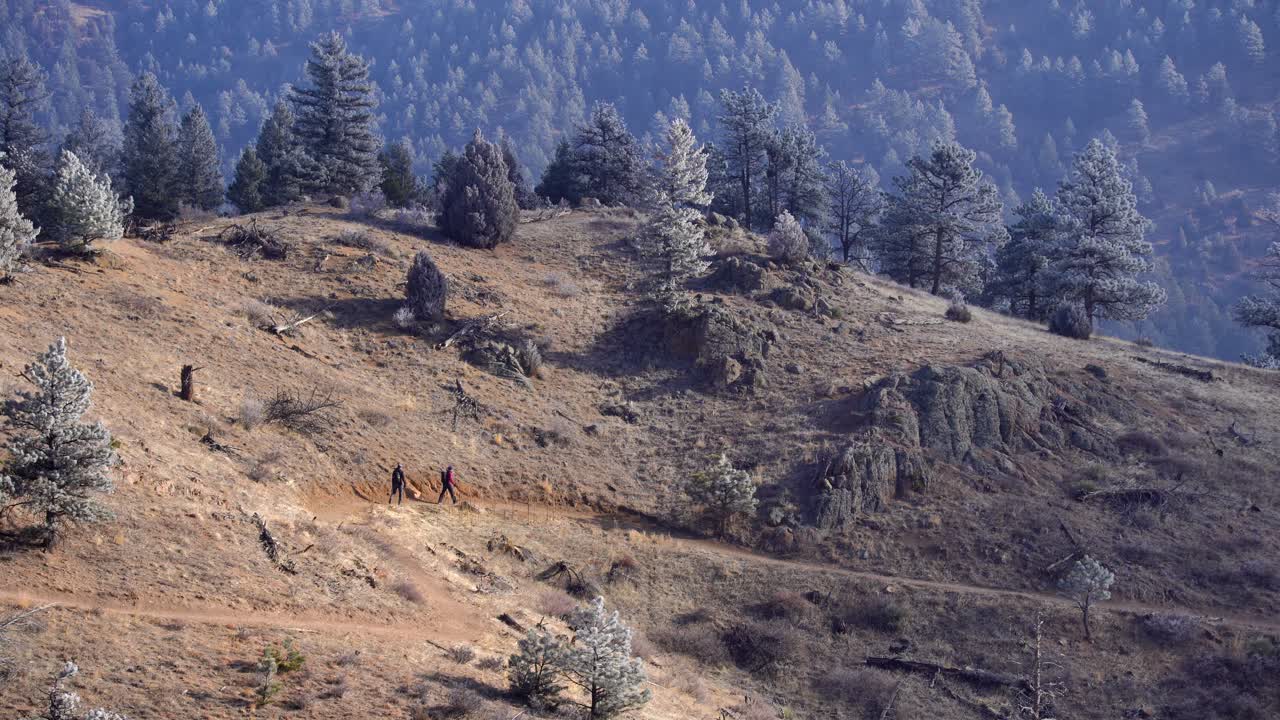 gente caminando en un sendero escarpado en las montañas rocosas