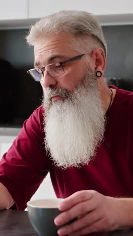 older man drinking coffee at home