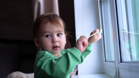baby girl playing at window