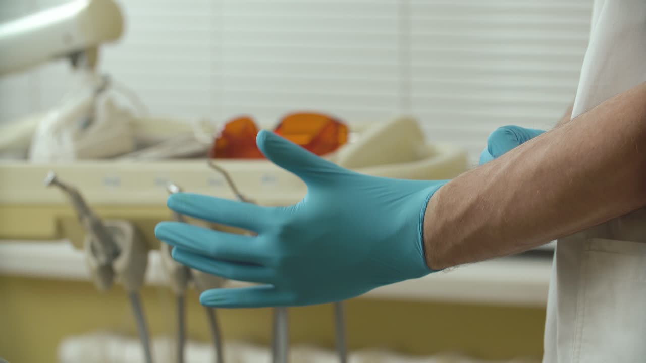 el dentista se pone los guantes.