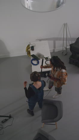 vertical video overhead shot of sound recordist and production assistant working on film set shooting movie or video in studio