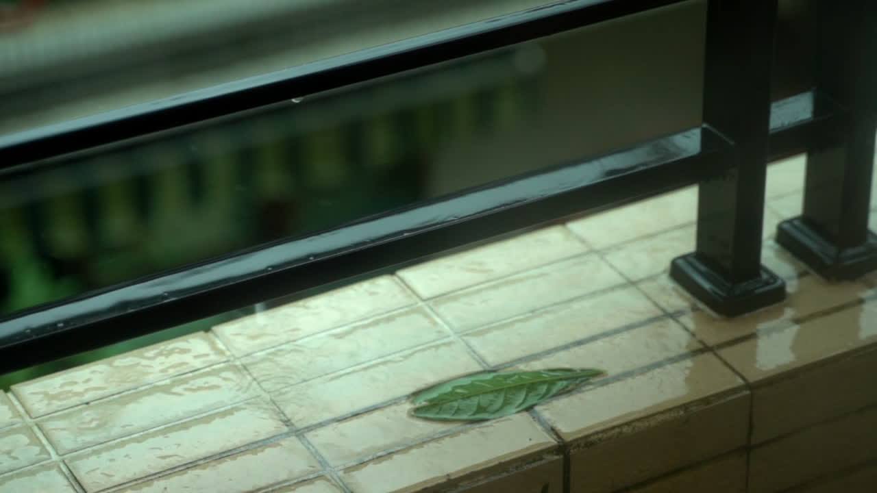 gotas de lluvia en cámara lenta en una cornisa del balcón