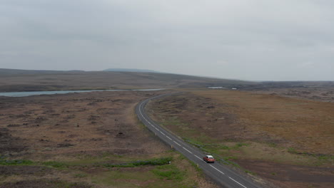 High-angle-view-majestic-landscape-panorama-of-iceland-countryside-in-cloudy-day-with-car-driving-ring-road.-Top-view-of-drone-following-car-driving-in-rock-desert-in-isolated-volcanic-Iceland