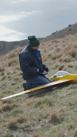 man with model aircraft on hillside